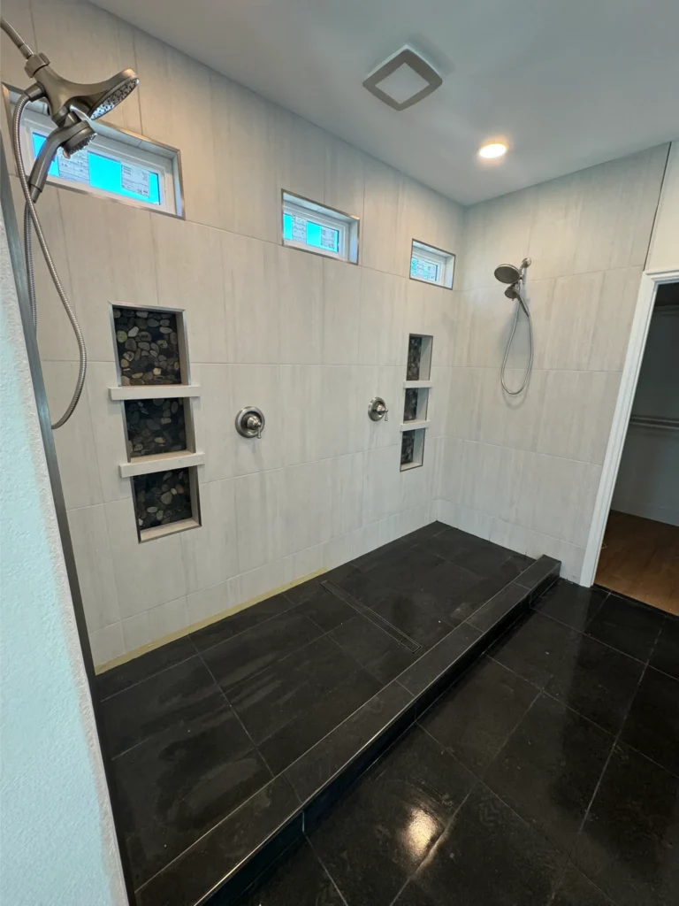 tile shower custom installation with black tile flooring double shower head