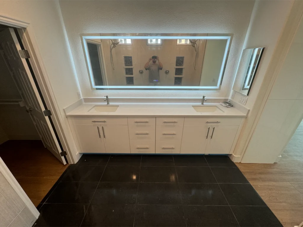 modern bathroom renovation, backlit mirror granite countertops and black tile flooring