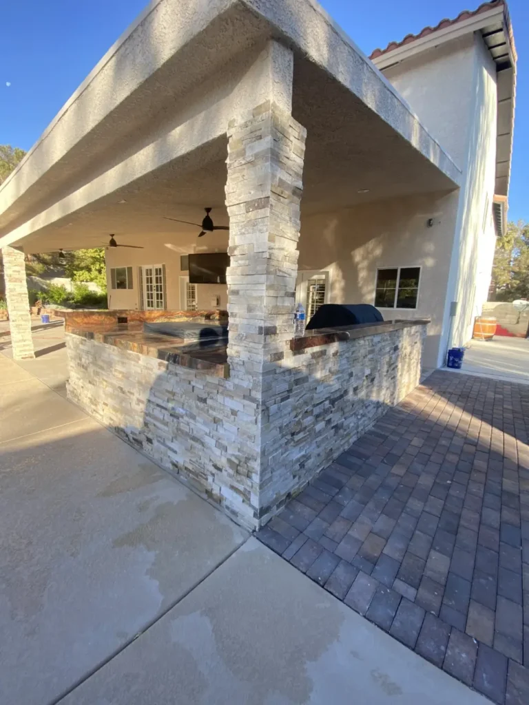 light outdoor stone wall installation with barbecue build in